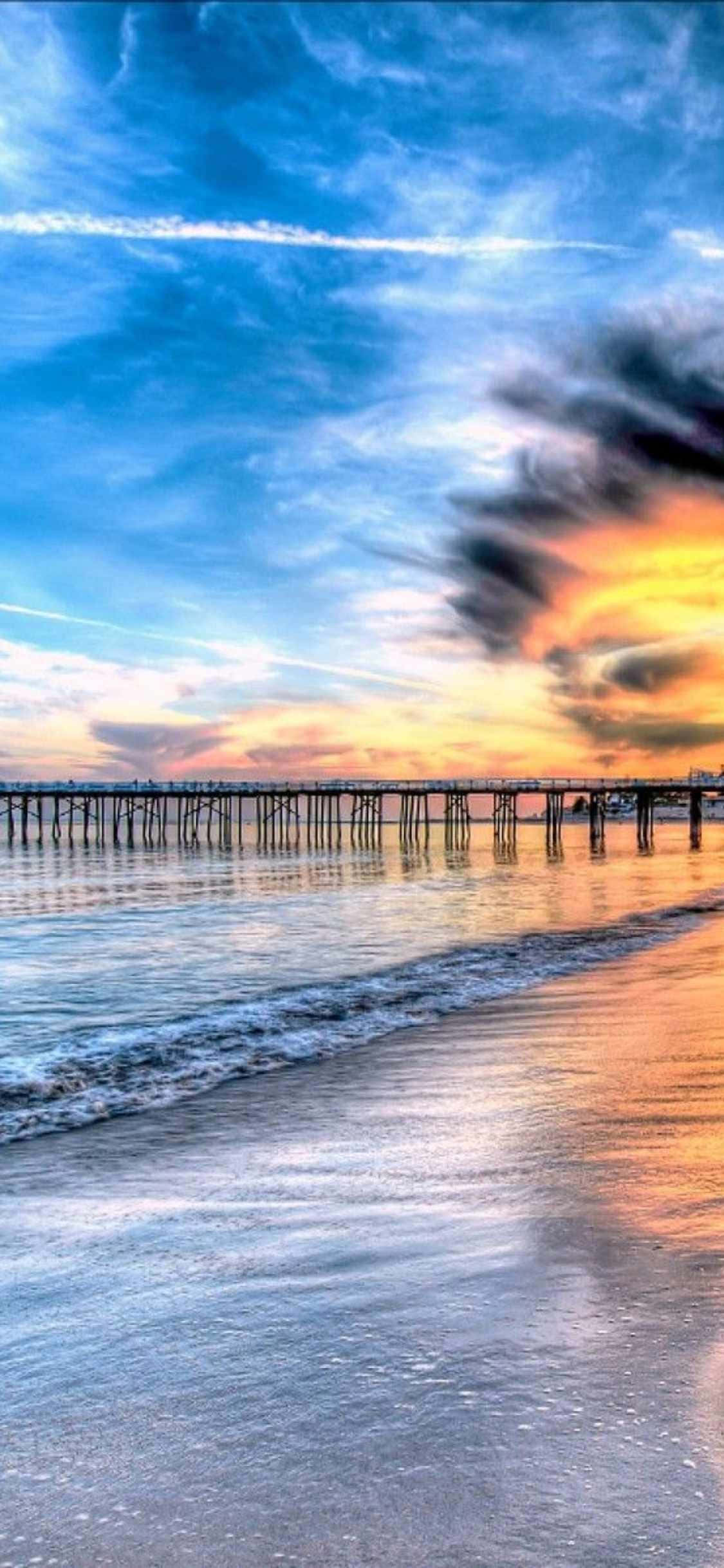 a pier with a sunset over the ocean Hình nền