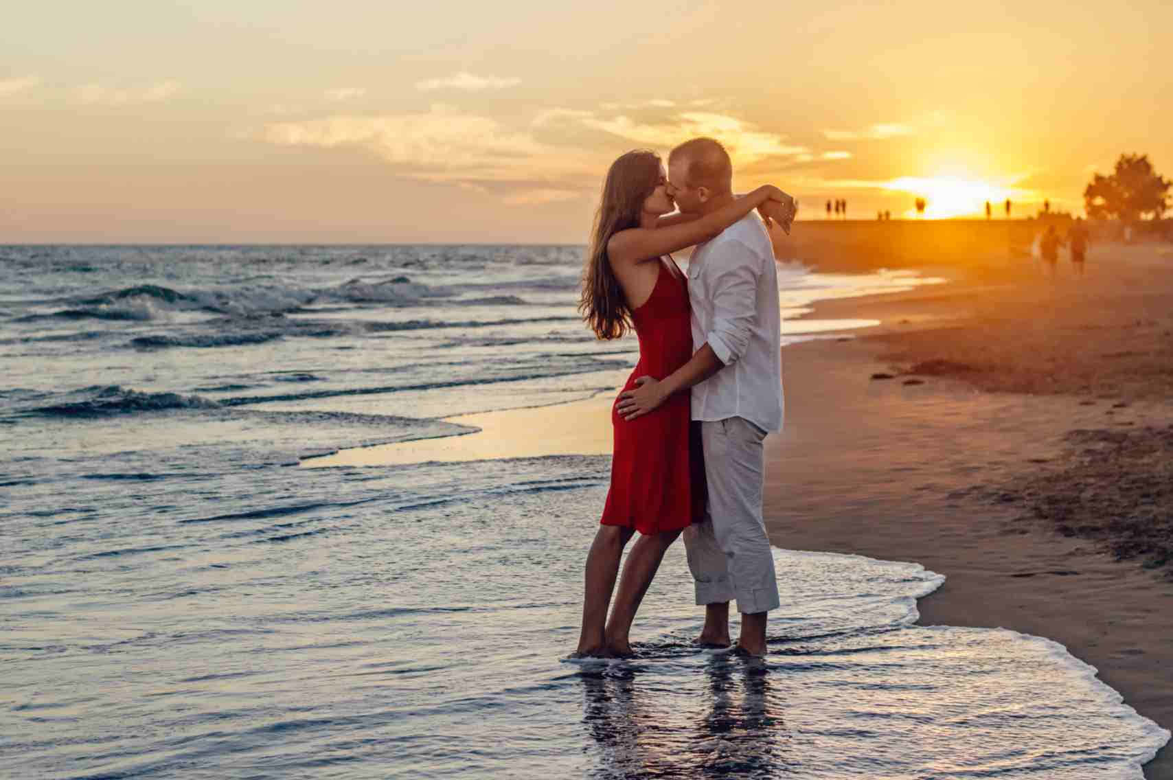 Cặp đôi hôn nhau lãng mạn dưới hoàng hôn rực rỡ Hình nền