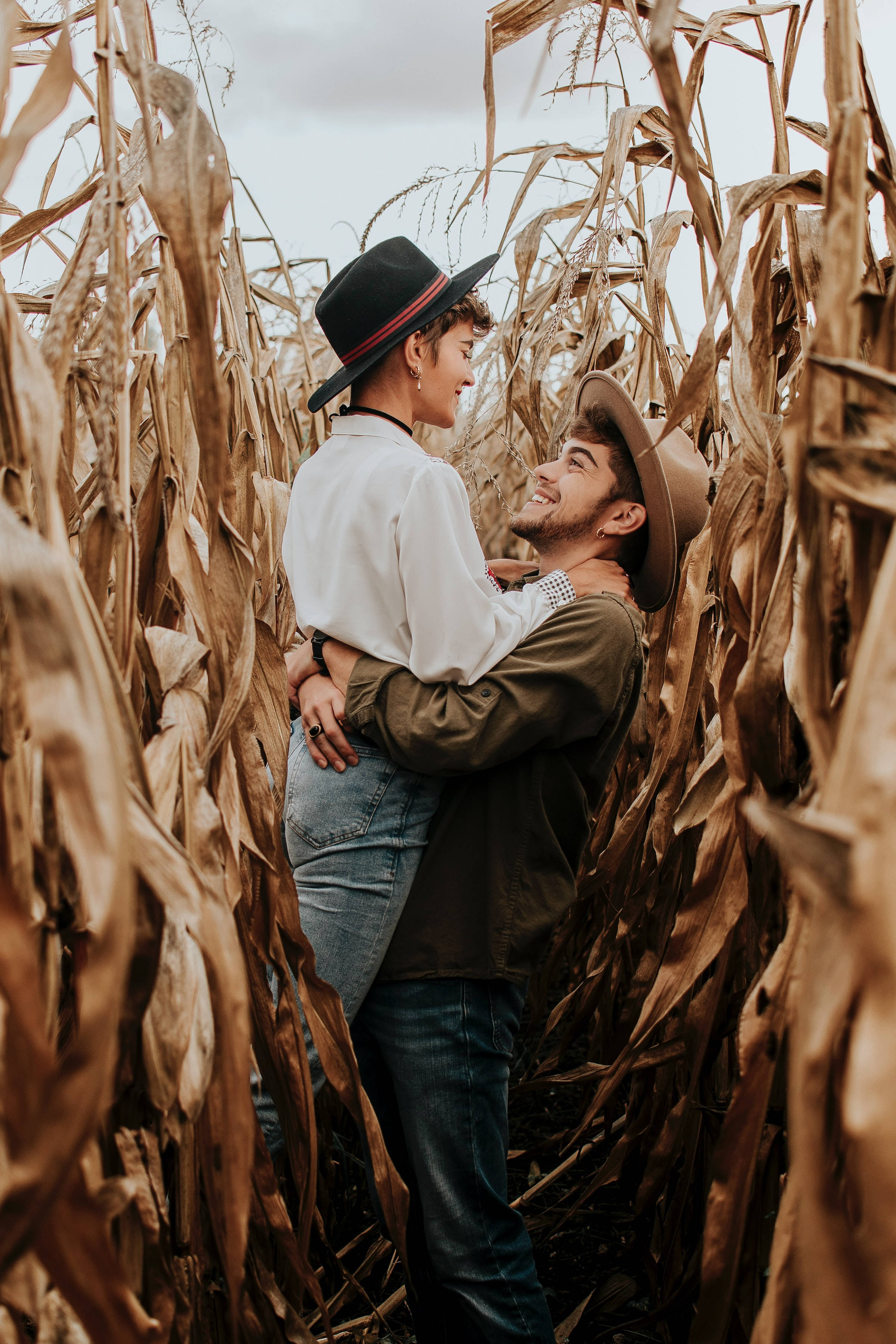 Cặp đôi cổ điển ôm nhau kiểu catcher hug trên cánh đồng ngô Hình nền