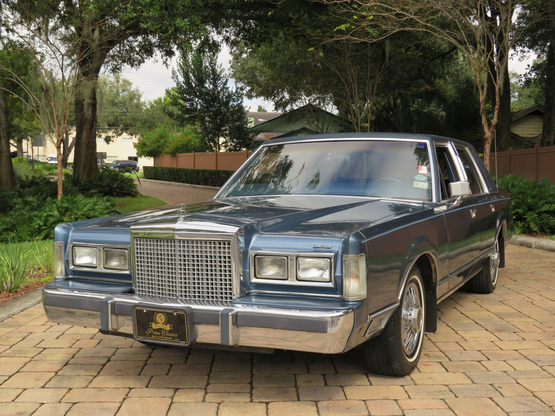 Chiếc Lincoln Town Car 1986 uy nghi đỗ trên đường lái xe lát đá Hình nền