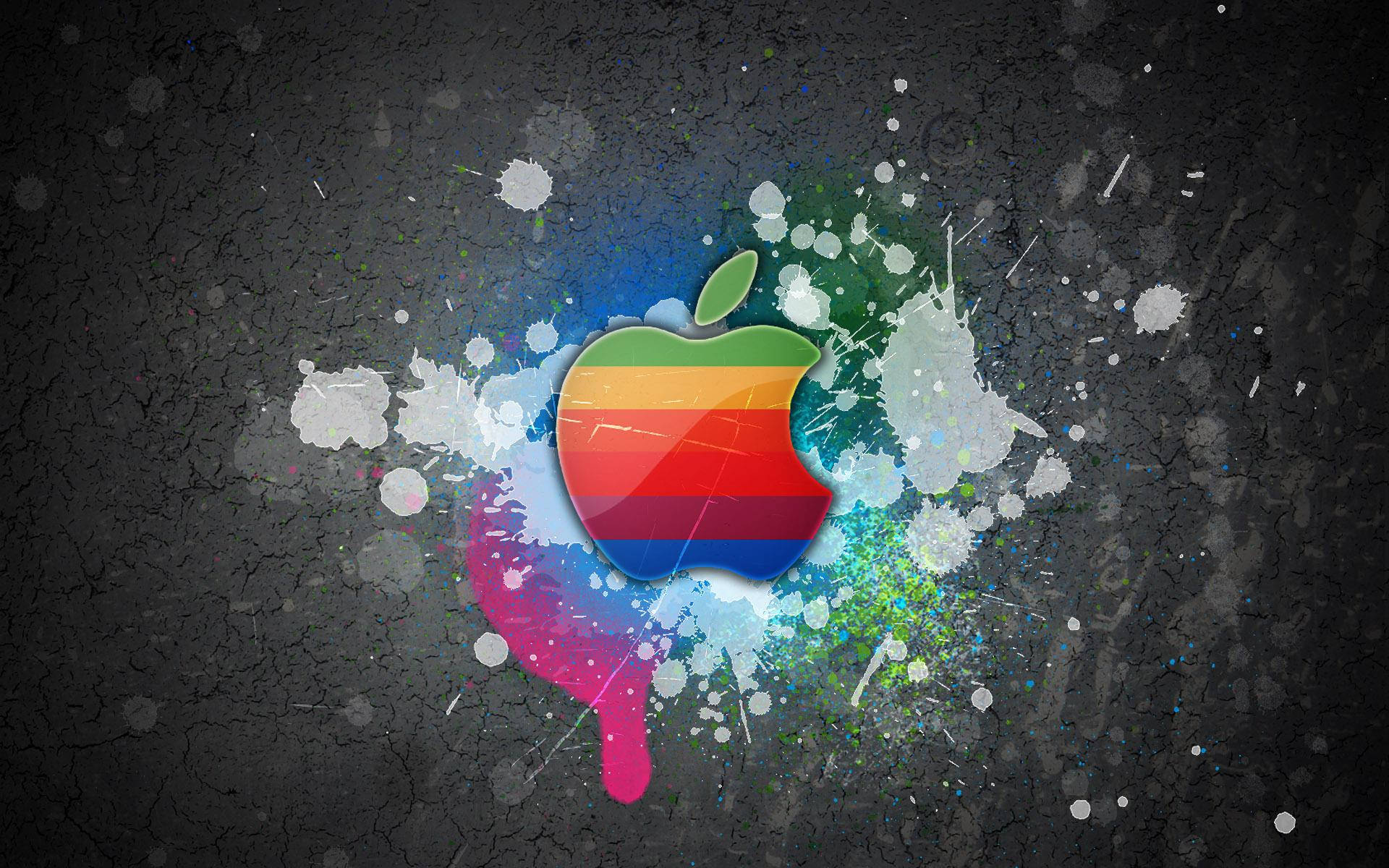 Hình nền đầy màu sắc mát mẻ của logo Apple Macbook trên tường xám với vết sơn bắn tung tóe