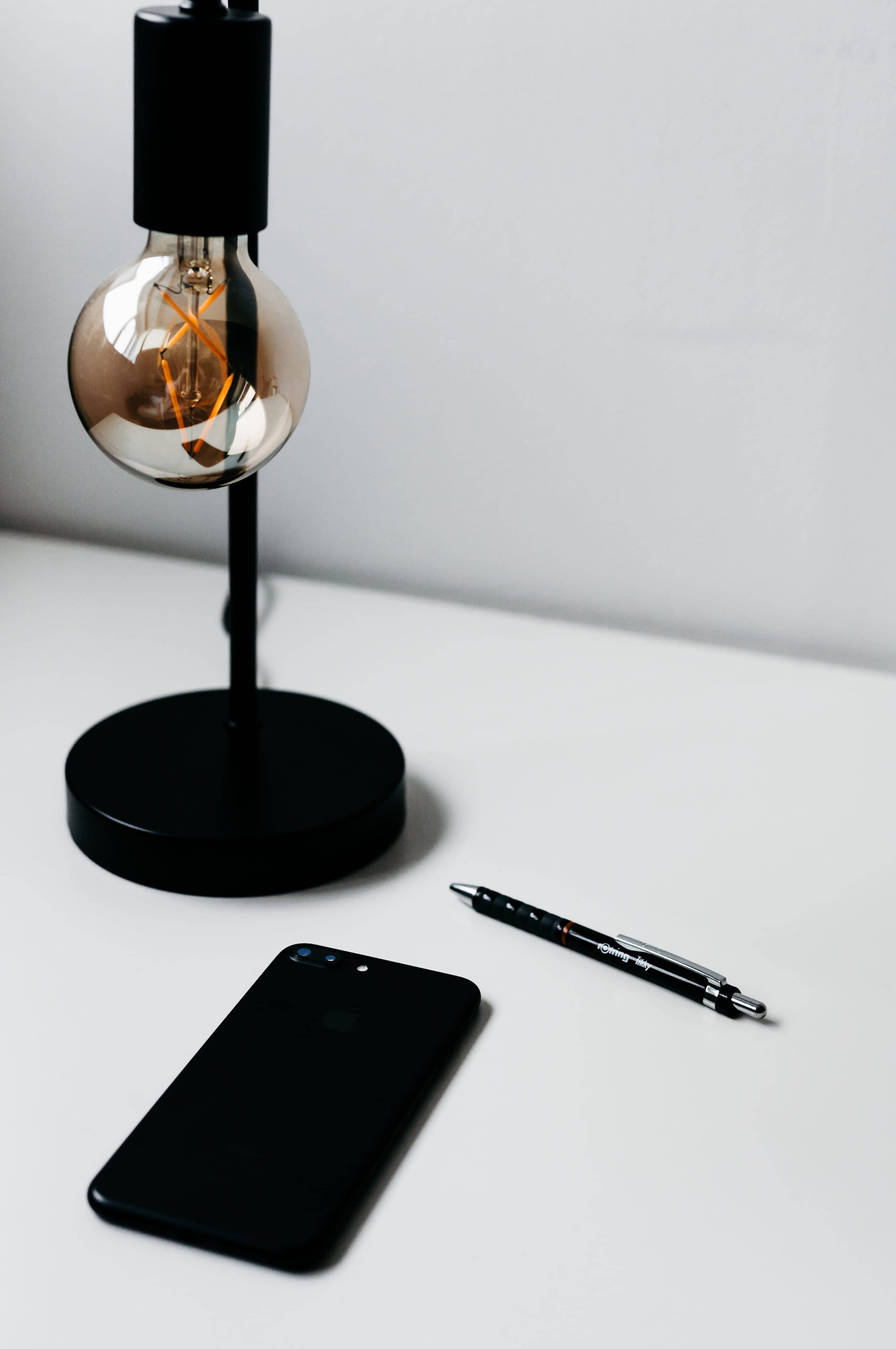 iPhone sáng trên bàn làm việc tối giản Hình nền