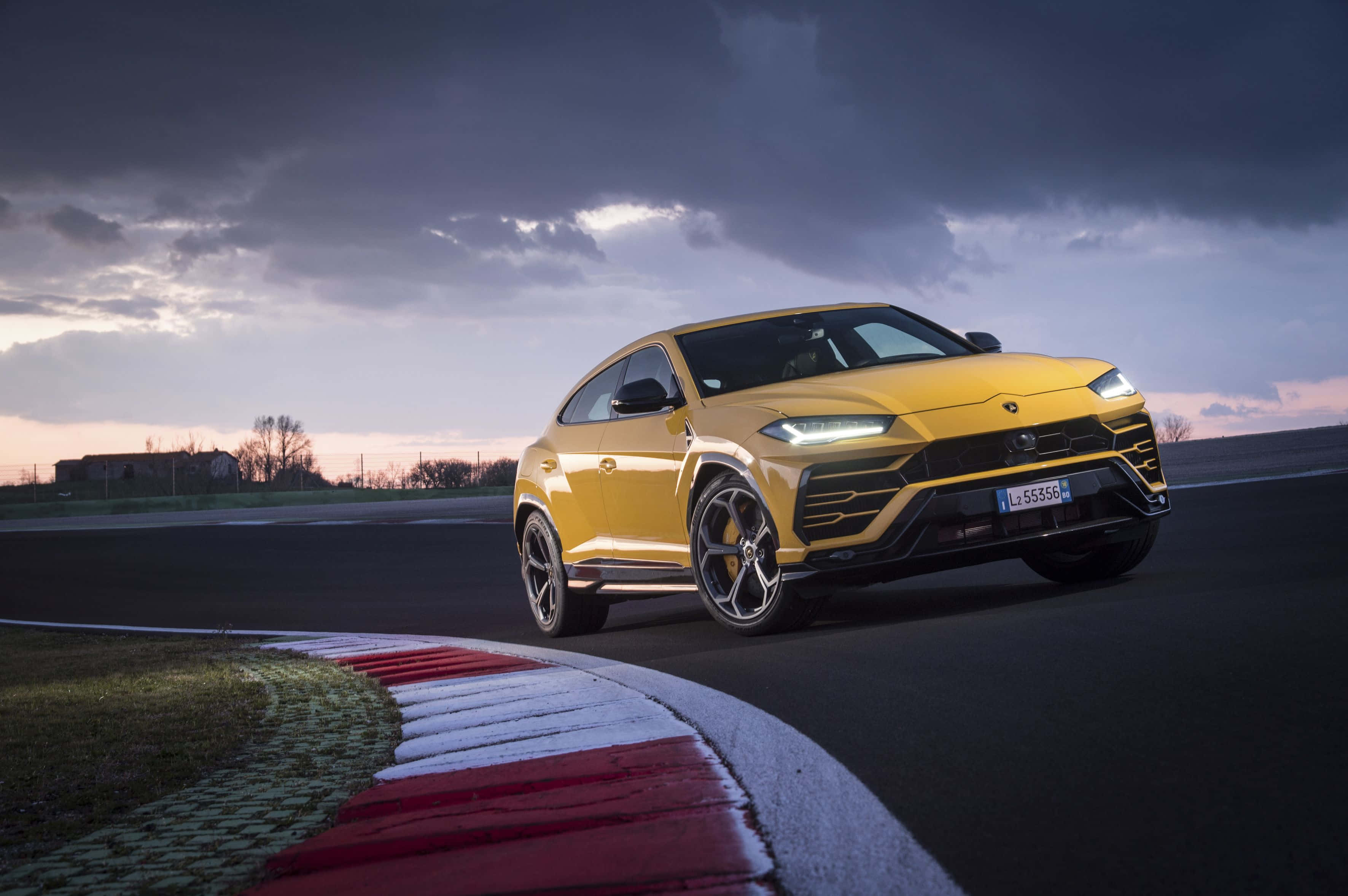 Lamborghini Urus - Một chiếc SUV màu vàng đang chạy trên đường đua Hình nền