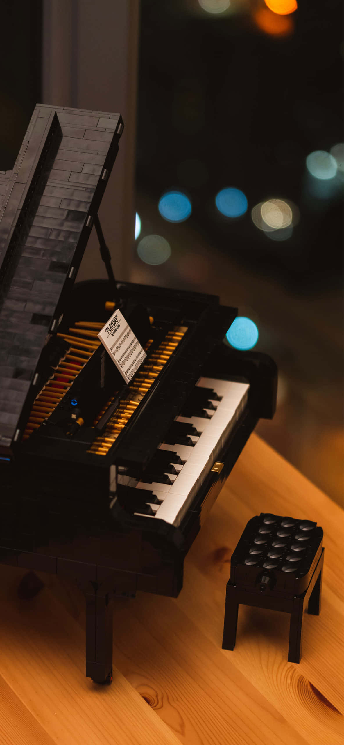 một cây đàn piano lego đặt trên bàn với một chiếc ghế đẩu Hình nền