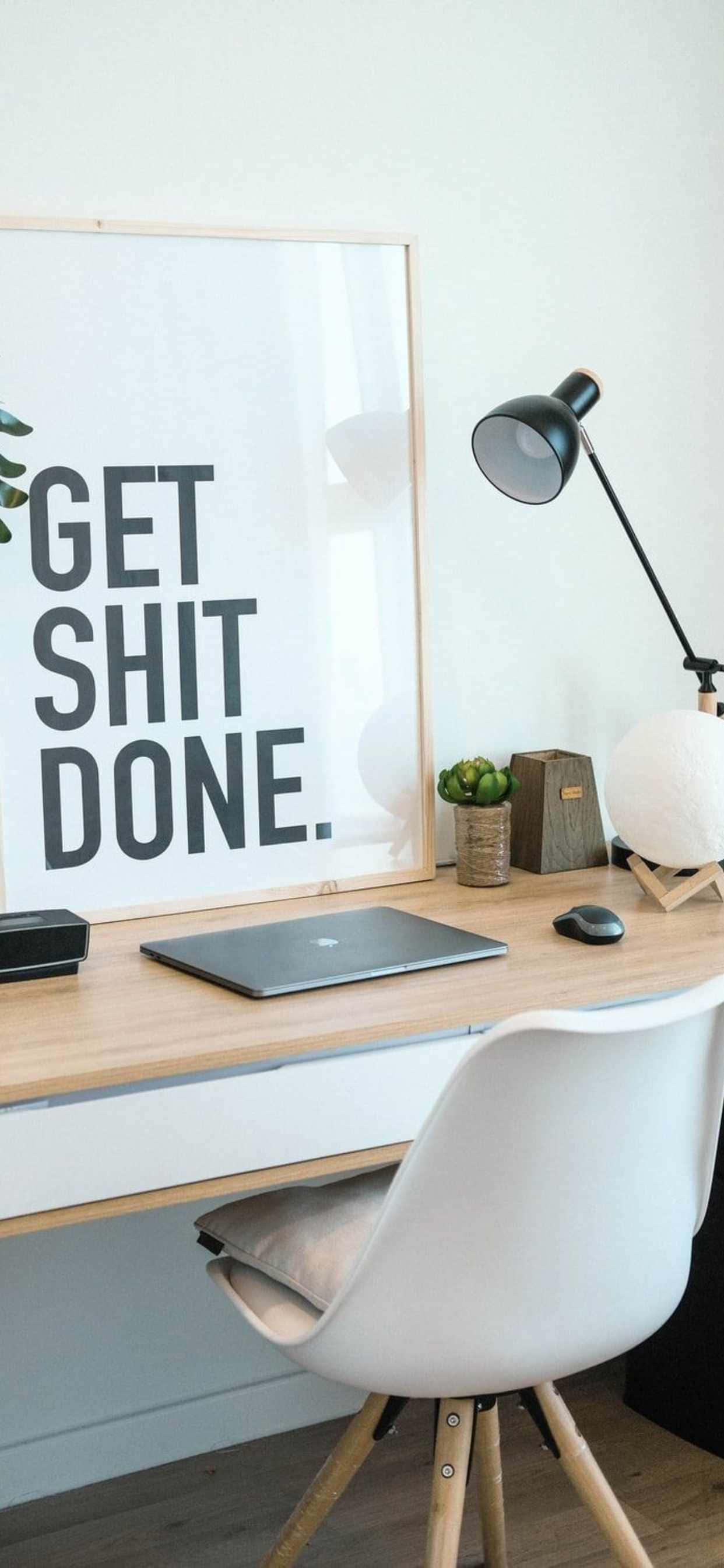 một chiếc bàn với tấm áp phích ghi 'get shit done' Hình nền