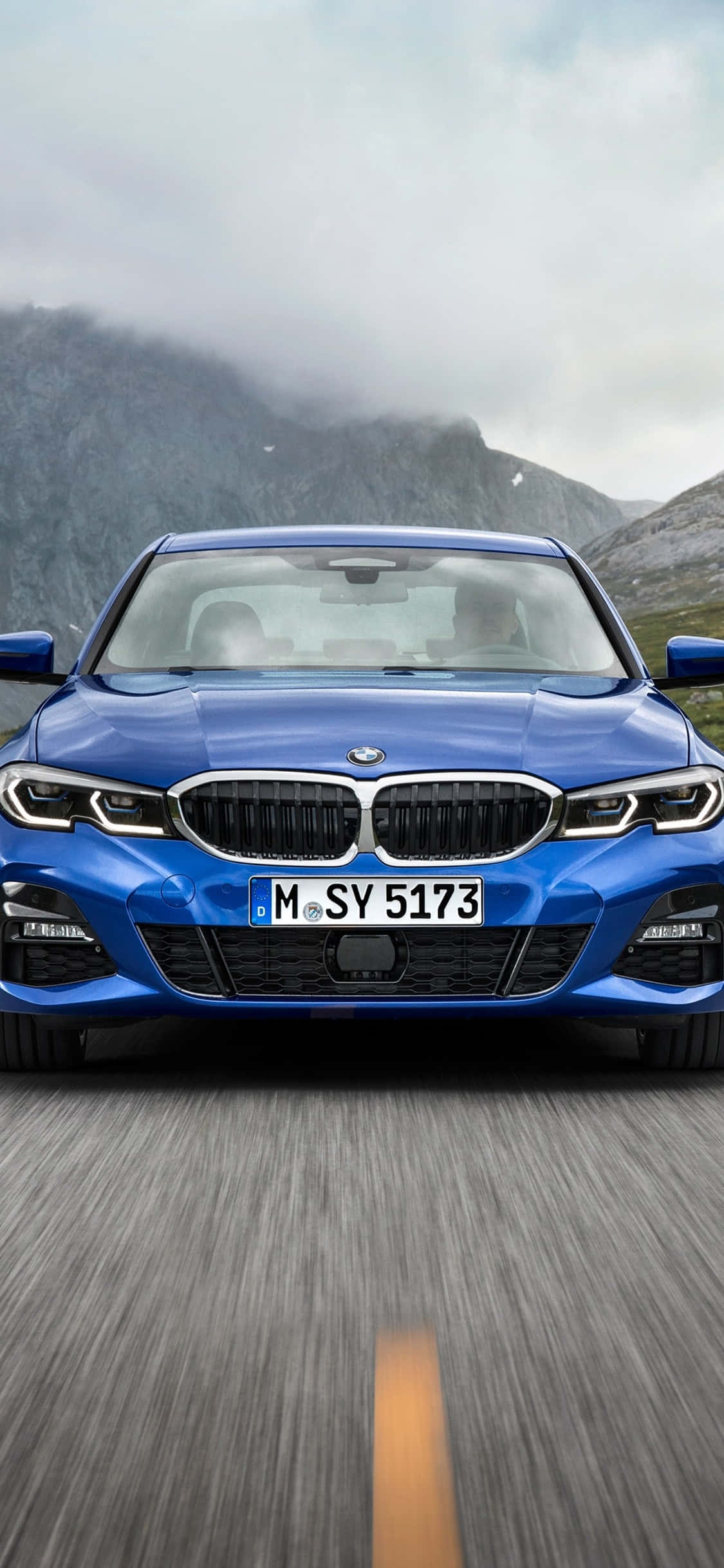 Một chiếc BMW X Series màu trắng đỗ cạnh một chiếc iPhone X Hình nền