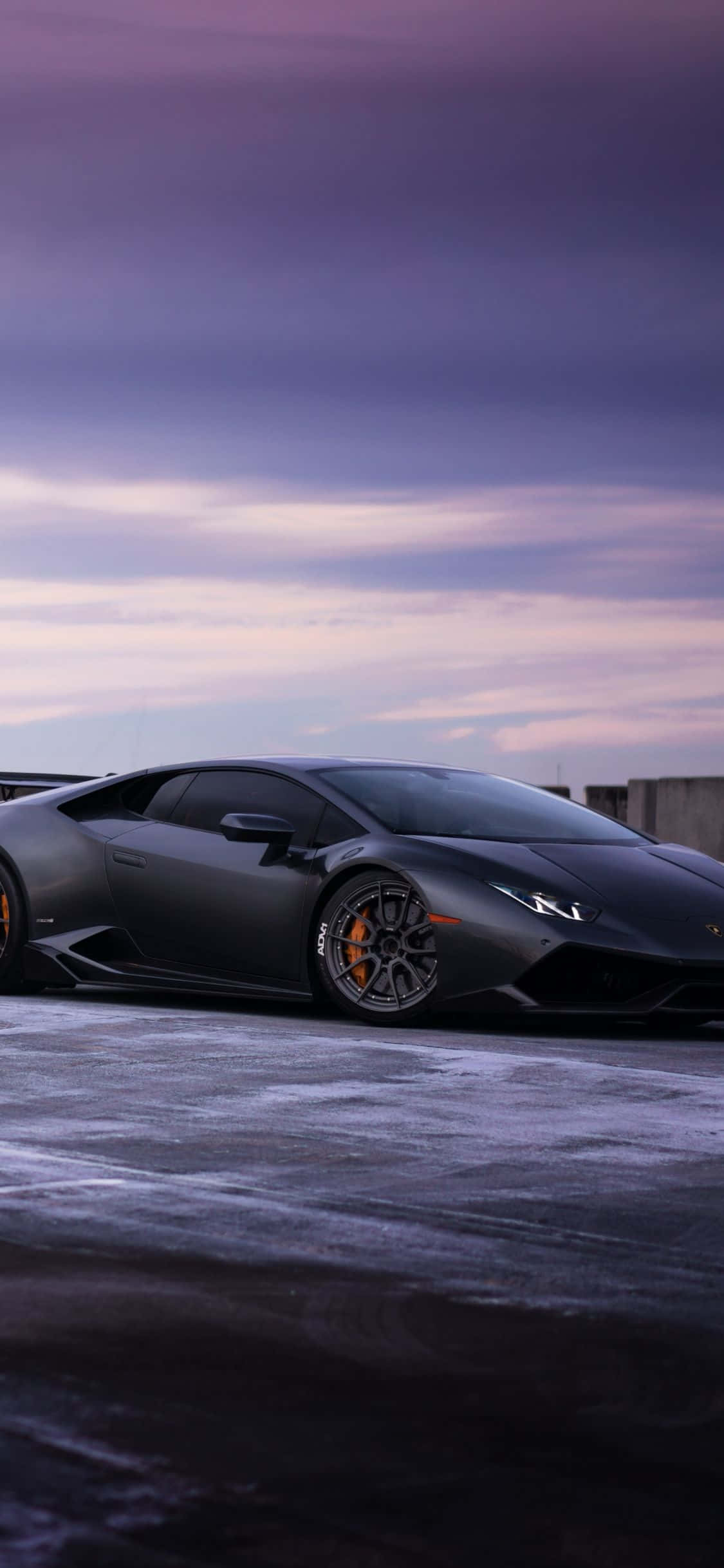 Một chiếc Lamborghini đen đỗ trên con đường tuyết Hình nền