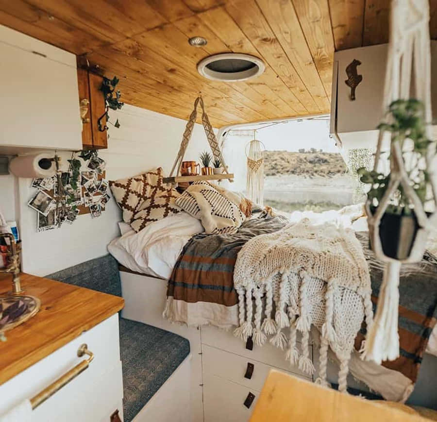 Một chiếc xe camper nhỏ với giường ngủ và bàn cạnh giường Hình nền