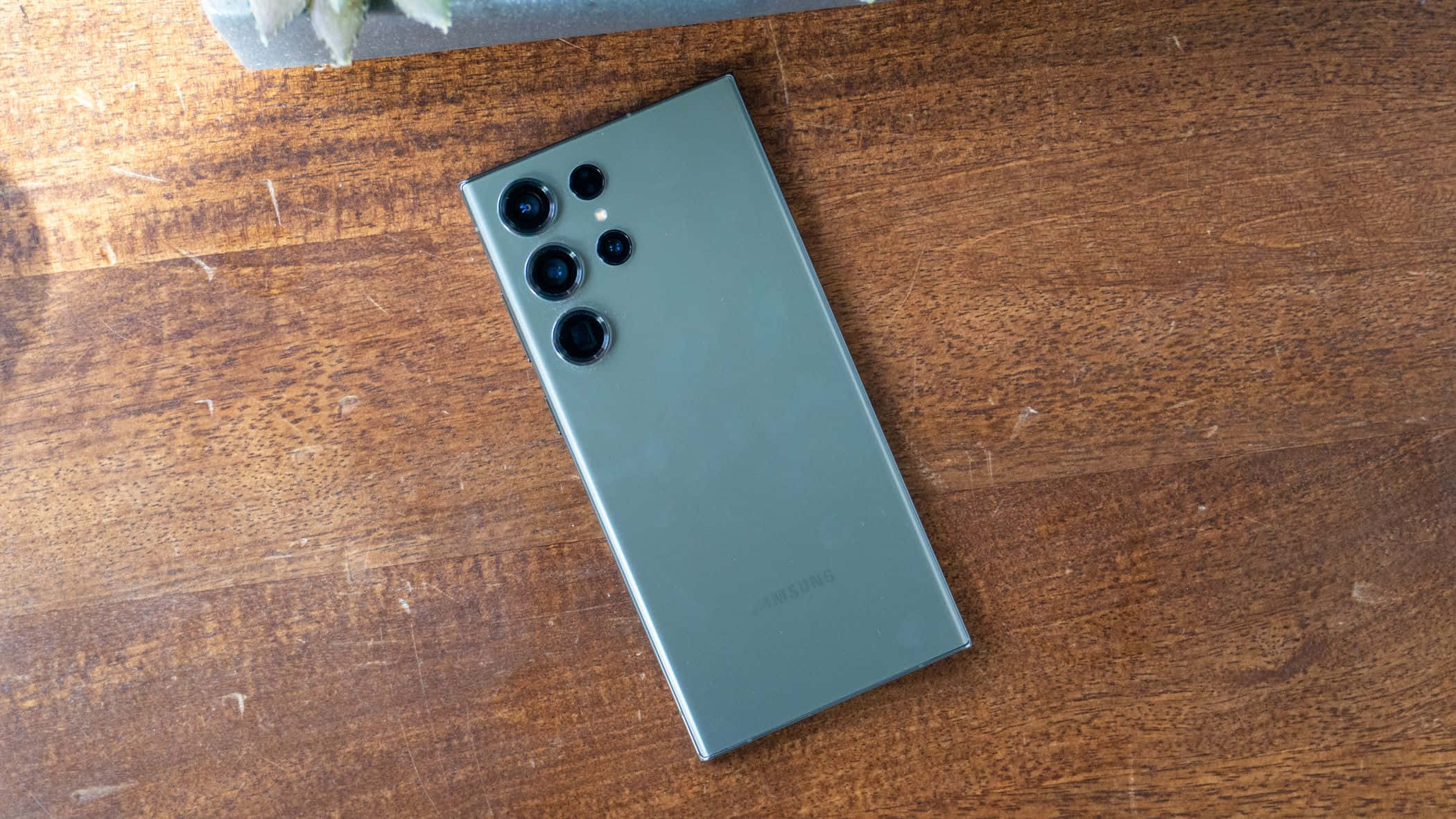 Samsung S23 Ultra Xanh Lá Cây Cụm Camera Sau Trên Bề Mặt Gỗ Hình nền