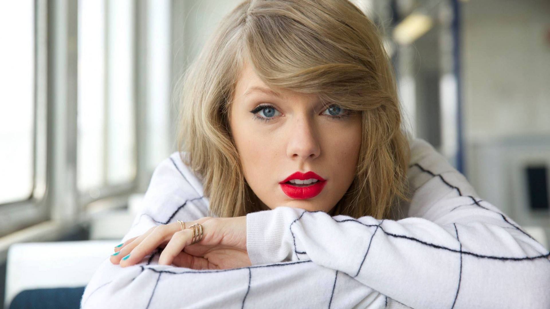 Ảnh nền Taylor Swift chống cằm trên bàn.