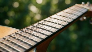 Cận cảnh dây đàn guitar với hiệu ứng bokeh xanh, ánh nắng ấm áp. — Âm nhạc thẩm mỹ Hình nền