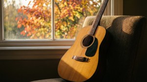 Cây đàn guitar bên cửa sổ với lá mùa thu và ánh sáng ấm áp. — Âm nhạc thẩm mỹ Hình nền