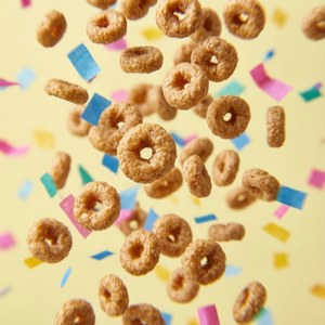 Hình nền vui tươi với Cheerios rơi như hoa giấy trên nền vàng pastel. — Huawei nova Flip Hình nền