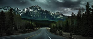 Ultrawide image of a long road amid a view of a mountain wallpaper.