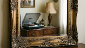 Một chiếc gương cổ điển trang trí phản chiếu nội thất retro ấm cúng.
