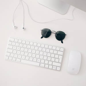 Hình nền tối giản của bộ Apple MAC trắng gồm iMAC, bàn phím không dây, chuột magic và tai nghe.